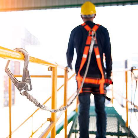 Construction worker prepares to cross scaffolding at a job site.