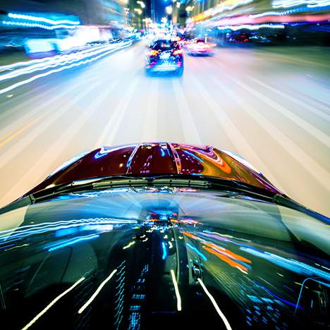 Blurred city lights at night from the POV of a car, portraying the dangers of drag racing illegally