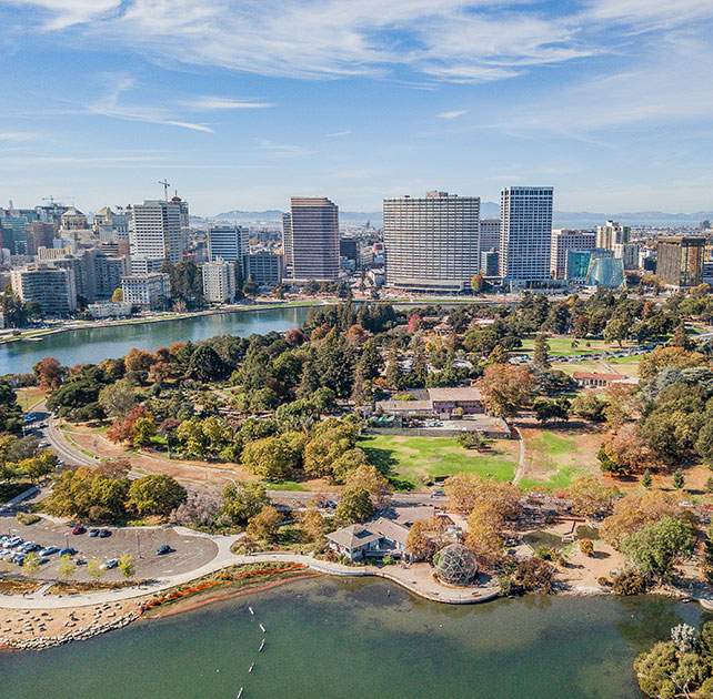 Aerial view of city skyline and park by water, an area served by Oakland car accident firm Avrek Law