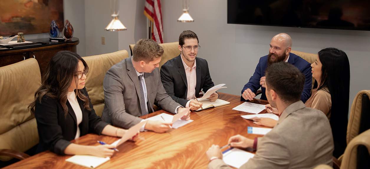 Lawyers at the car accident personal injury attorney firm Avrek Law discussing a case at a table