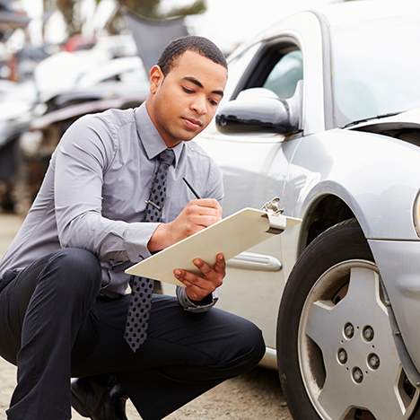 Insurance adjustor inspects car for damage - learn when you need a lawyer vs insurance company