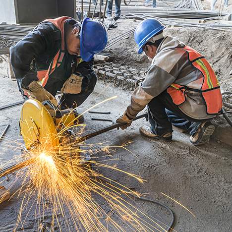 Two construction workers using circular saw - find the best Riverside construction accident lawyers