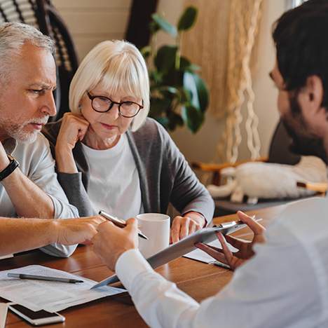 Elderly couple looking over paperwork with man, perhaps asking personal injury interview questions