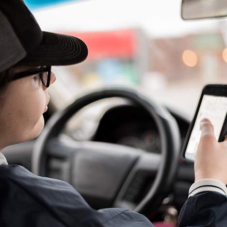 Driving teen looking at phone - why is distracted driving a problem especially for teen drivers?