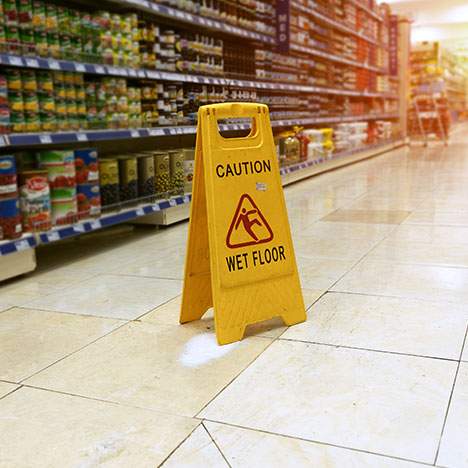 A wet floor sign indicates the potential for a slip and fall injury inside a retail establishment.