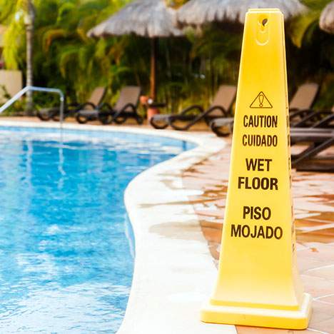 Caution sign next to wet pool - learn how how to sue a hotel for injury