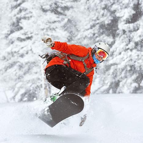 Individual in snow gear on snowboard - discover the latest snowboarding injury statistics