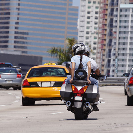 Two people riding one motorcycle in traffic - where do most motorcycle accidents occur?