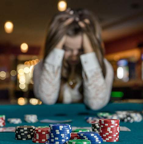 Woman in pain at a poker table - find out how to file a lawsuit against a casino