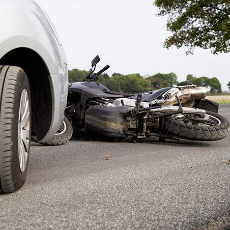 Overturned motorcycle next to car wheel - find a motorcycle injury law firm in Bakersfield