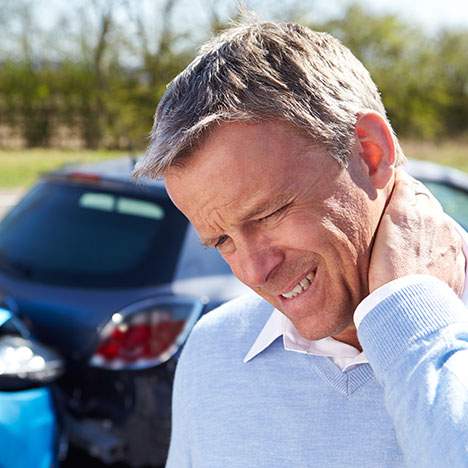 Man grimacing and holding neck after car accident - can I sue for whiplash?