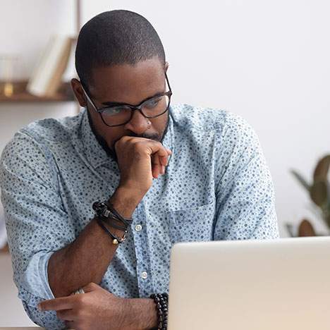 Man sitting in front of a laptop with a look of concern - can a car accident cause memory loss?