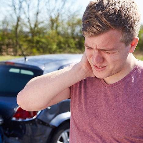 man holding his neck post whiplash