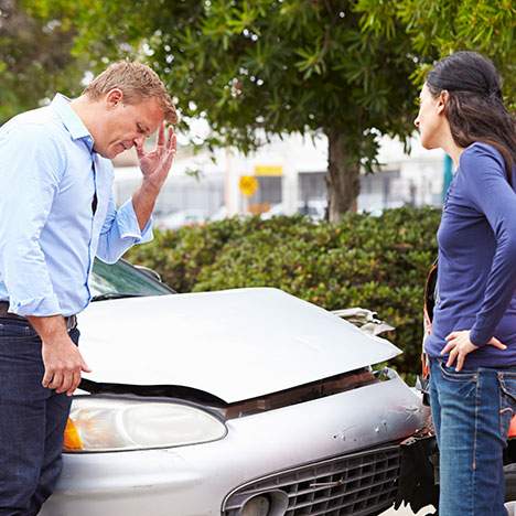 man and woman looking at a car accident they were just in