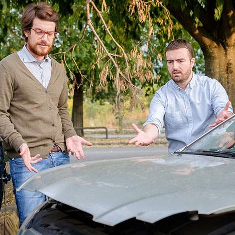 two men opening a hood after a car accident