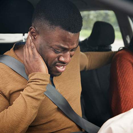 man holding back of neck in car